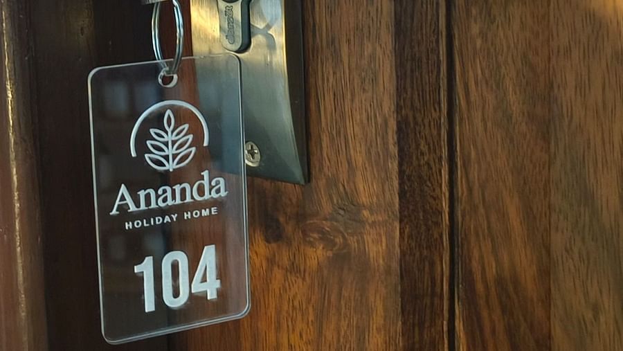 A key hanging on the door with a key chain saying  Ananda 104 room at Ananda Holiday Home, Wayanad 3