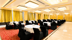 Bright hotel lobby lounge at Golden Tulip Kukas Jaipur with cushioned seating, indoor plants, marble flooring, and natural light from large windows