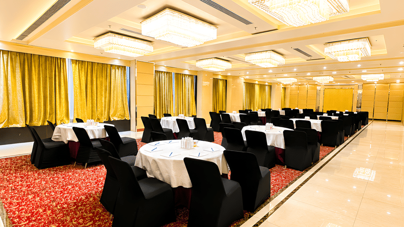 Bright hotel lobby lounge at Golden Tulip Kukas Jaipur with cushioned seating, indoor plants, marble flooring, and natural light from large windows