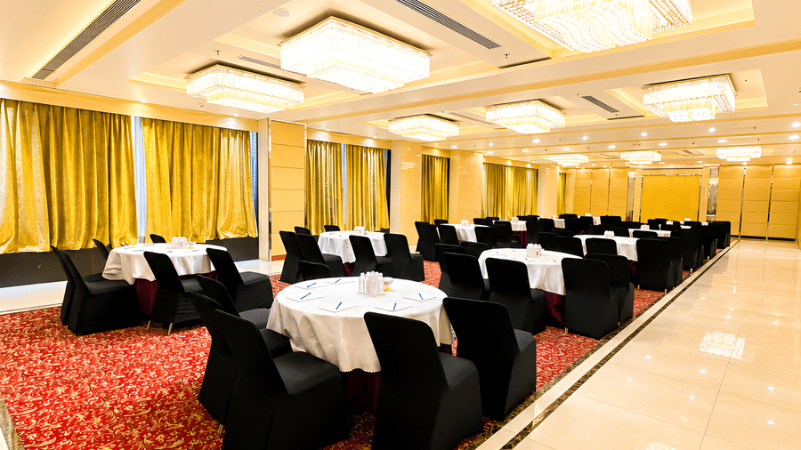 Bright hotel lobby lounge at Golden Tulip Kukas Jaipur with cushioned seating, indoor plants, marble flooring, and natural light from large windows