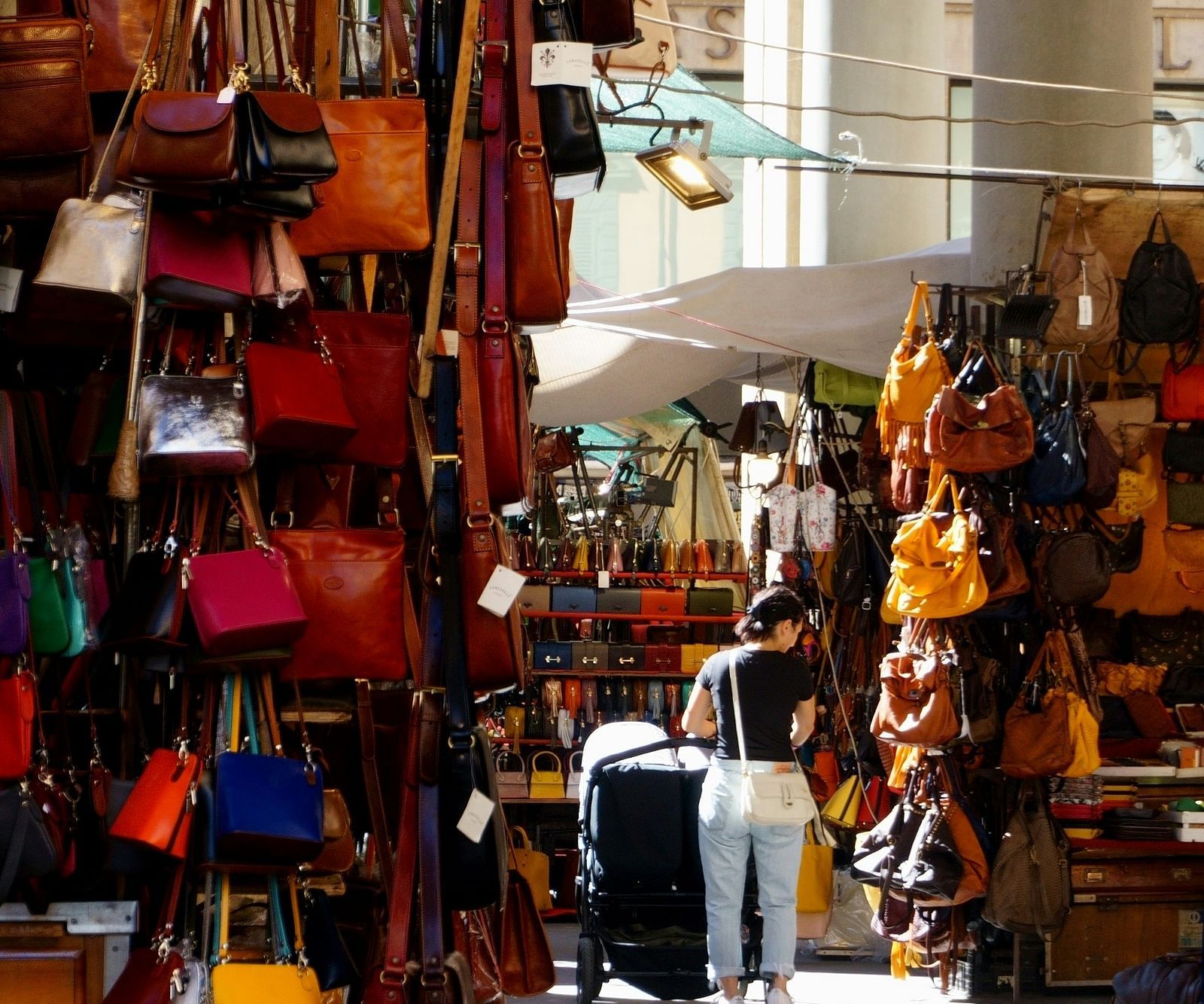 A woman buying different types of handbags