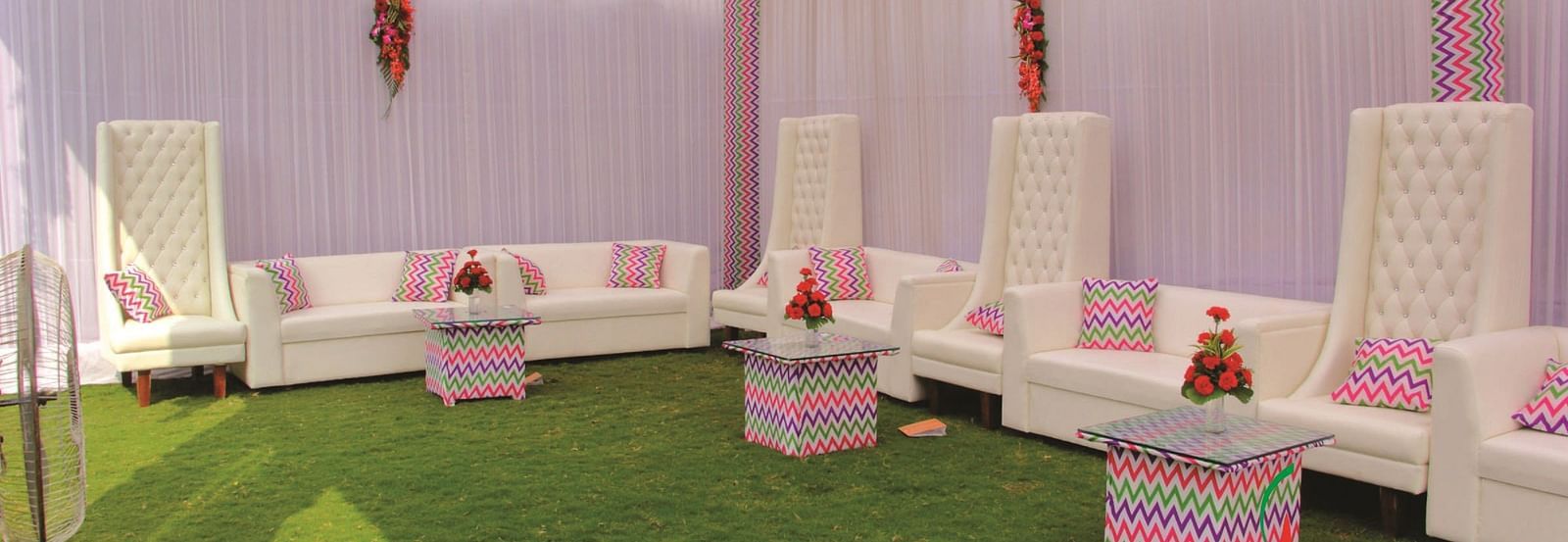 Side-angle view of a seating area with white sofas and pink canopy for an event | Gemini Continental