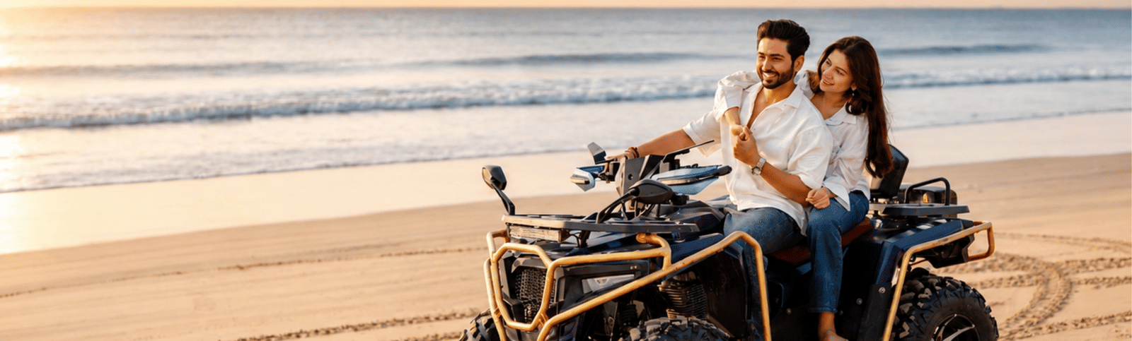 Two people riding a quad bike across the sand at sunset, with tyre tracks and the sea behind, at MAYFAIR Palm Beach Resort, Gopalpur-on-Sea.