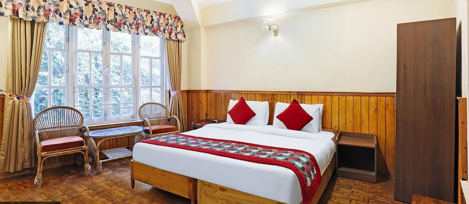 A full view of a room that has a bed and a huge glass window | Summit Newa Regency & Spa, Pelling