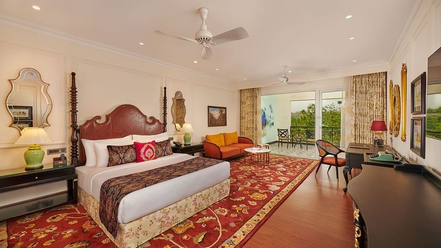 Grand bedroom with vibrant red carpet, antique furniture, and natural light.
