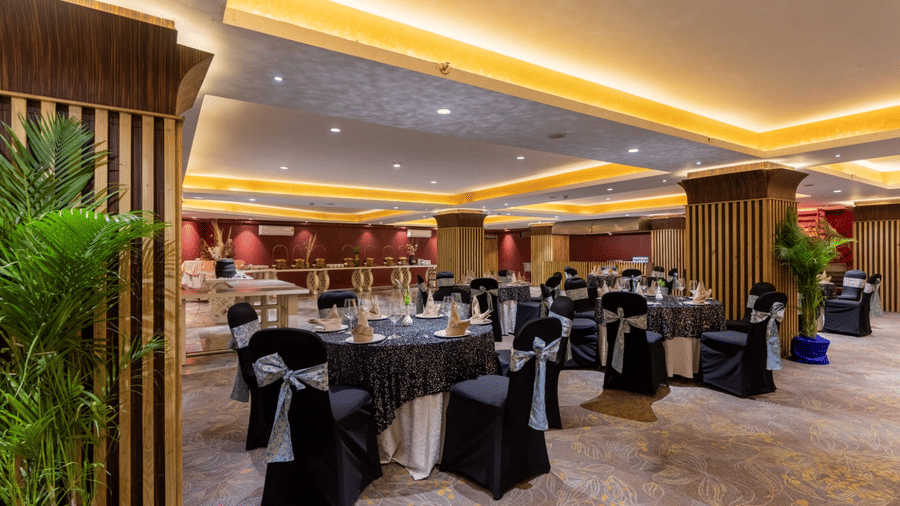 Galaxy Banquet Hall at Papaya Tree Hotels set up with round dining tables and elegant decor for formal dinners and celebrations.