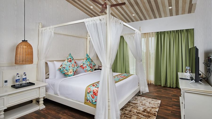A room at Swosti Chilika Resort with a double bed and white ambience