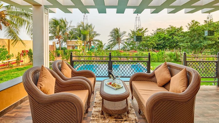 Open seating area beside the swimming pool at Swosti Chilika Resort