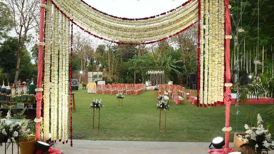 Entrance gate at Tisya Farms, Gurgaon decorated with fabric, lights, and flowers in a symmetrical arch.