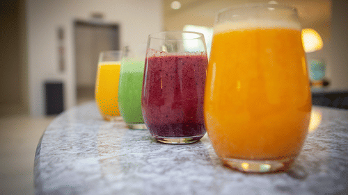 4 glasses of beverages on a glossy surface placed next to each other at YO1 Longevity & Health Resorts