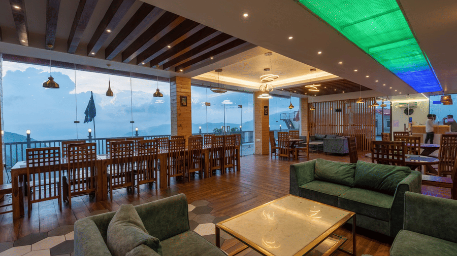 Spacious indoor dining area with panoramic mountain views at MV Acosta, Mussoorie.