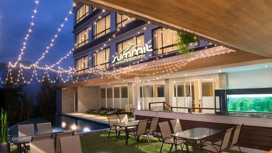 A pool side dining arrangement illuminated by hanging lights - Summit North Star, Gangtok