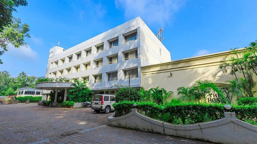 Exterior view of VITS Shalimar, Ankleshwar, with a road leading to the hotel and greenery around.