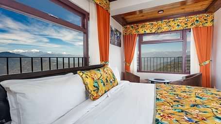 Image of a room with bed and two large windows with view of the mountians at Summit Sherpa Mountain Hotel & Spa, Kalimpong