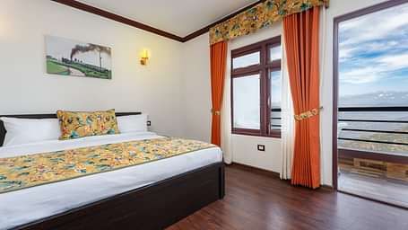 Image of a room with bed and attached balcony at Summit Sherpa Mountain Hotel & Spa, Kalimpong