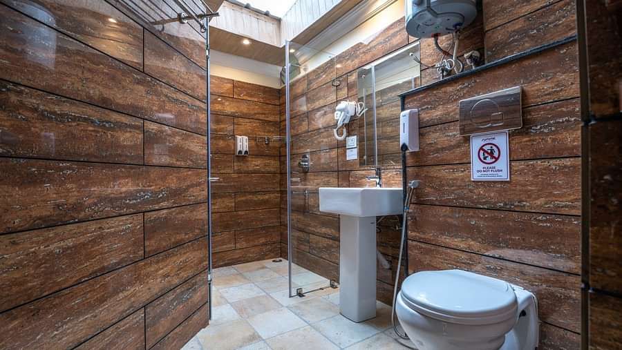  The bathroom of the Premium Suite with a Balcony features a glass partition for the shower area and includes a geyser