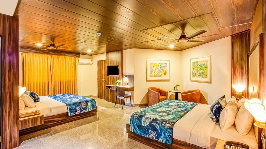  Family room with a private balcony featuring two beds, ceiling fans, and large framed photographs