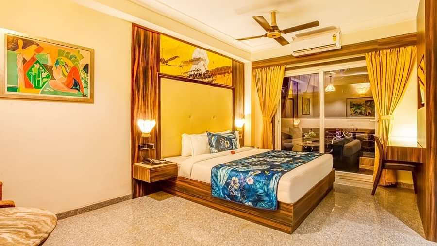 Premium room with a private balcony features large beds, expansive side windows covered by curtains pushed to the side