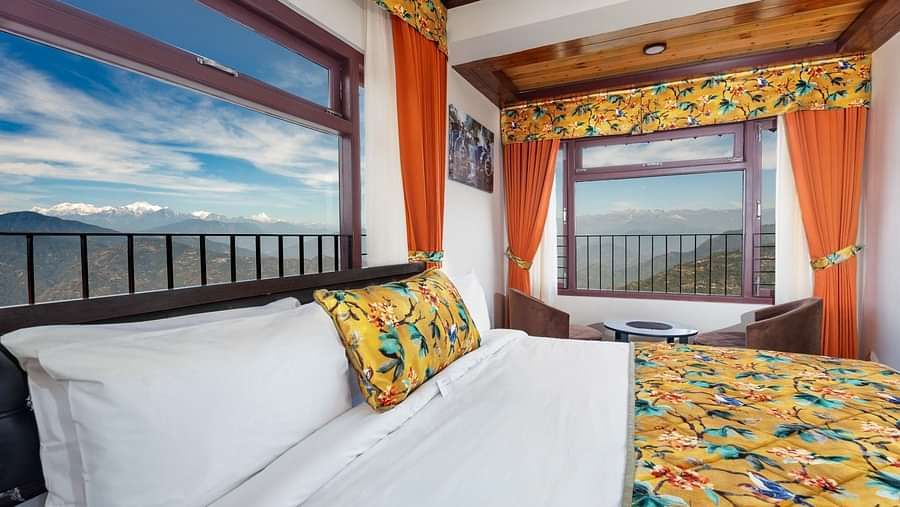Image of a room with bed and two large windows with view of the mountians at Summit Sherpa Mountain Hotel & Spa, Kalimpong