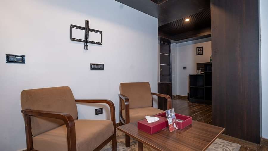 Image of two cushioned chairs and a tea table in the room.