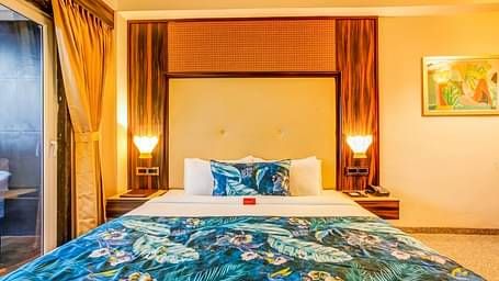  Spacious bed with two bedside tables, each adorned with a lamp, viewed from the front