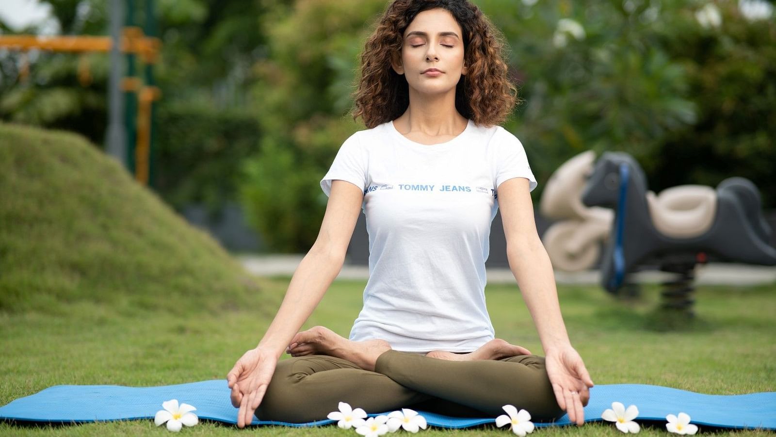 A  lady meditating in a park