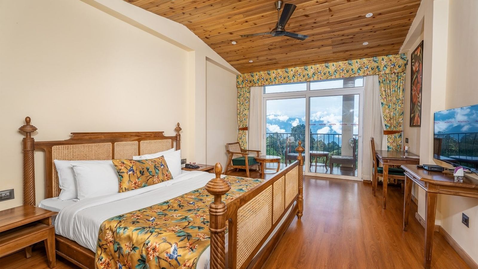 A room at Summit Barsana Resort & Spa, Kalimpong with a double bed, a television and large windows