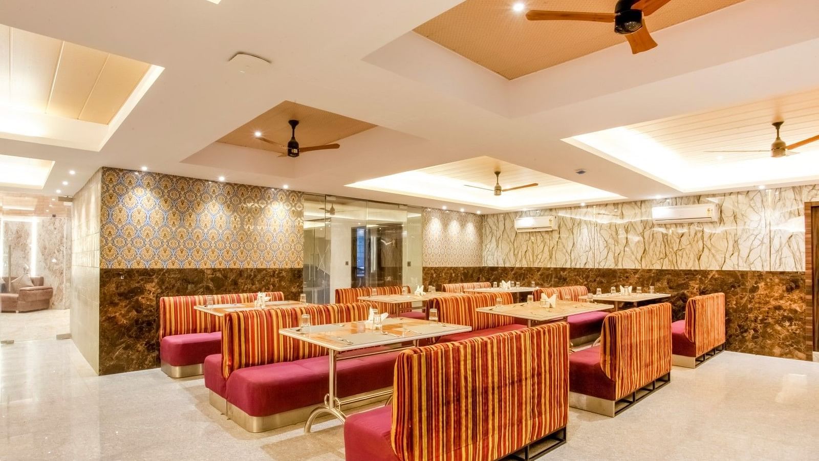  Dining area featuring spacious booth seating, with ceiling fans installed above to ensure added comfort