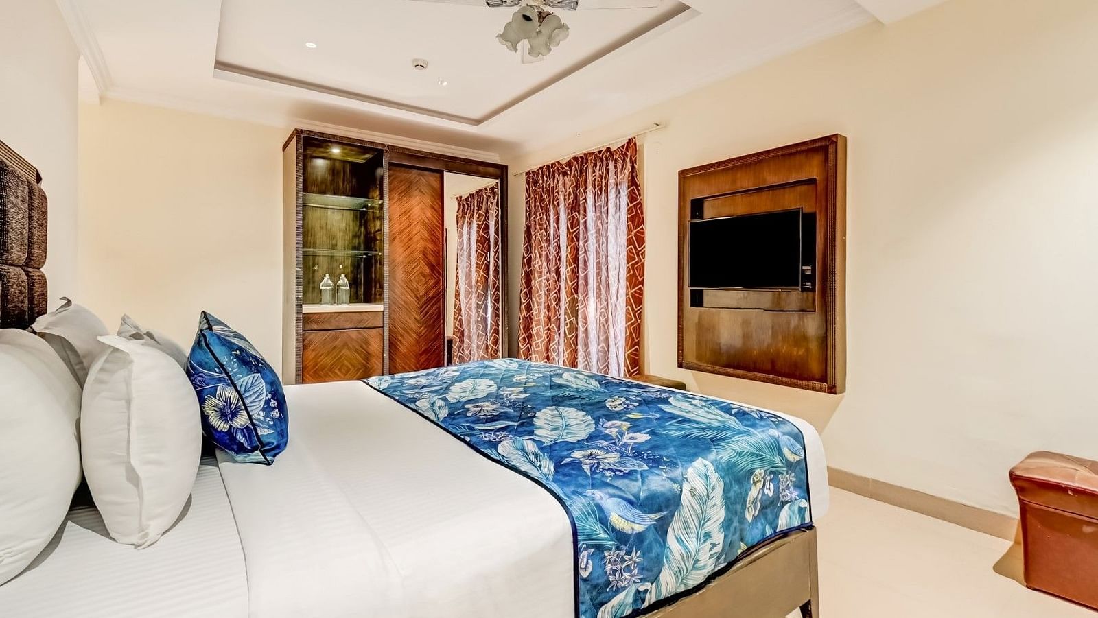 View from the bedside table showcasing the plush, comfortable bed and the wall-mounted television