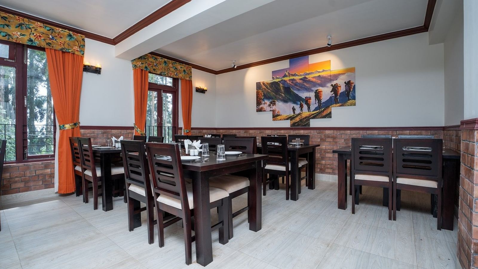 Image of a dining room with tables and chairs and large poster on the wall at Summit Sherpa Mountain Hotel & Spa, Kalimpong