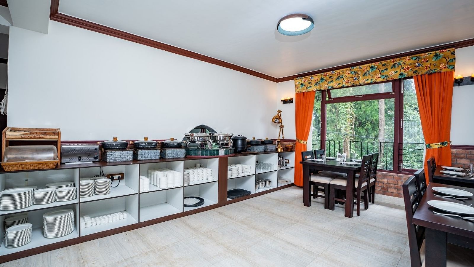Image of a dining space with a shelf filled with cutlery at Summit Sherpa Mountain Hotel & Spa, Kalimpong