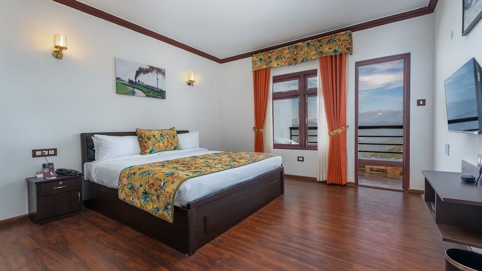 Side view of a room with bed and and an attached balcony Image of a room with bed and a frame above the bed at Summit Sherpa Mountain Hotel & Spa, Kalimpong