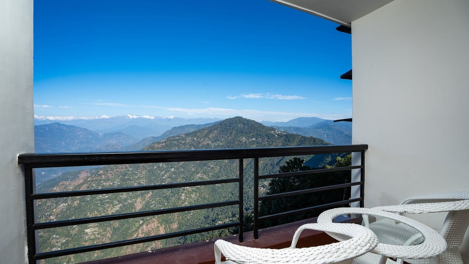 Image of a balcony with seating area and view of the lush mountains at Summit Sherpa Mountain Hotel & Spa, Kalimpong