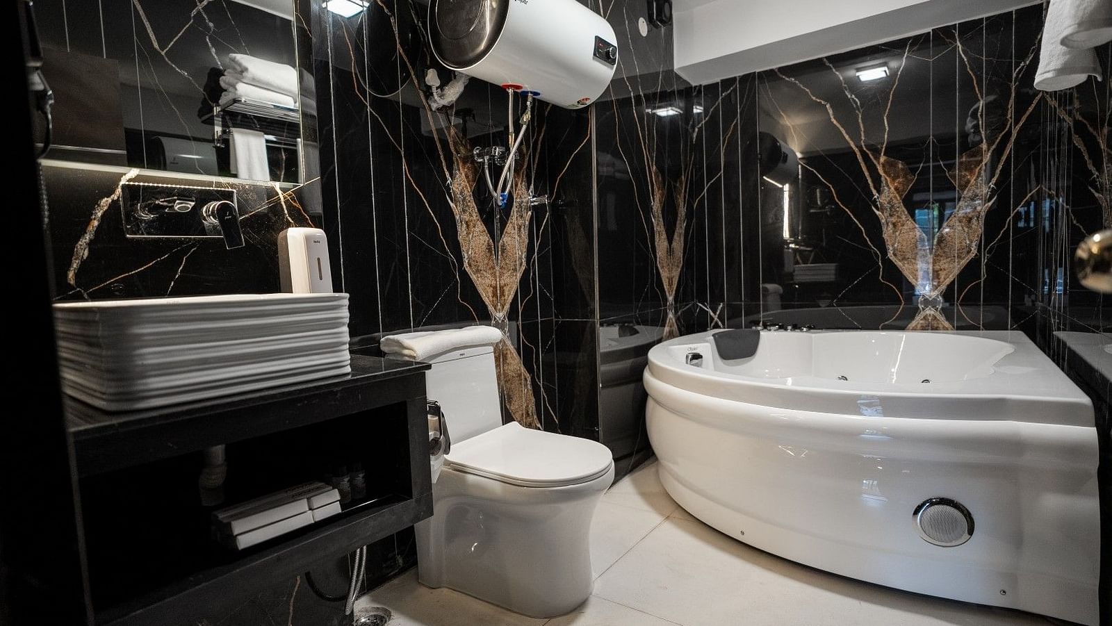 A sot of the well equipped bathroom featuring a jacuzzi, geyser and other ammenities. 