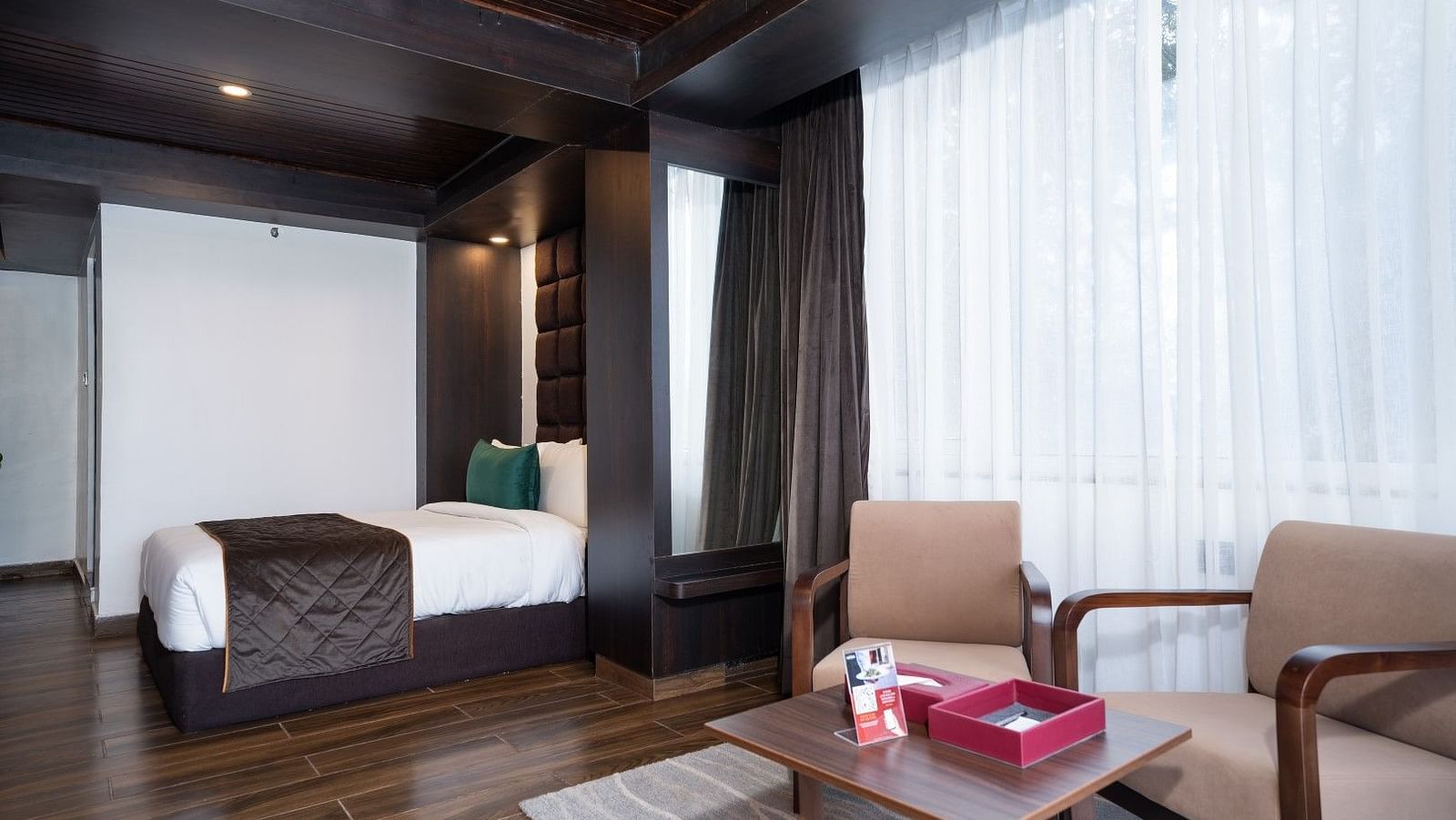 Image of a bed along with king size bed along with the two comfortable chair for your relaxation.