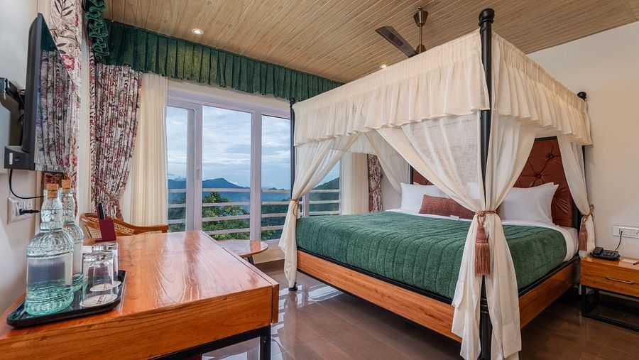 A spacious bed with ample lighting, complemented by wooden furniture