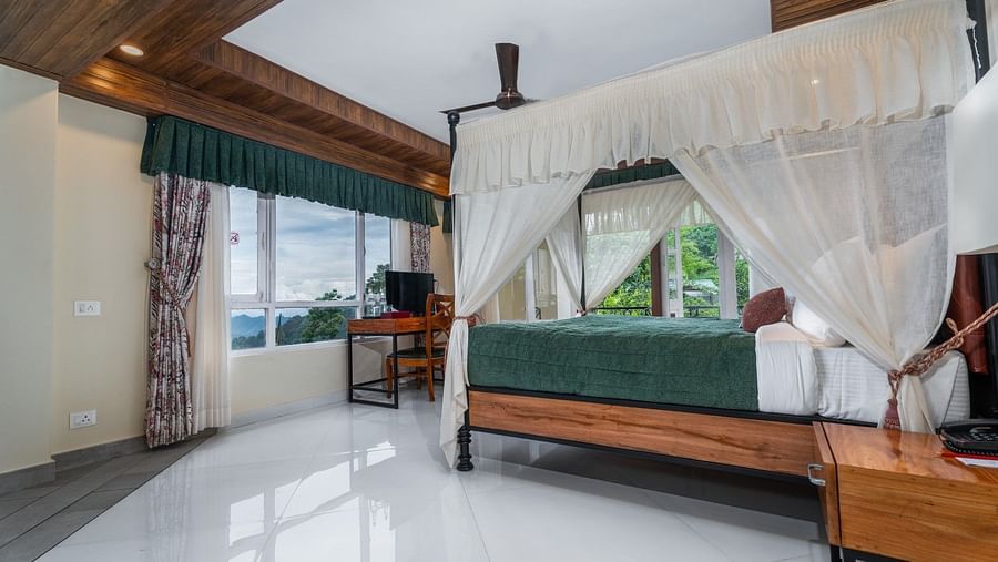 A spacious bed with ample lighting, complemented by wooden furnishings