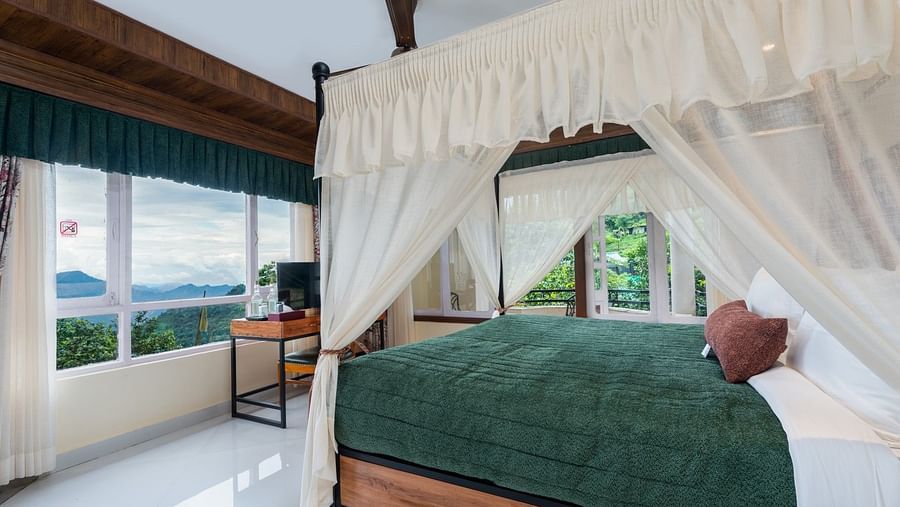 room featuring a large floor-to-ceiling window that offers a view of the mountains, complemented by a generously sized bed
