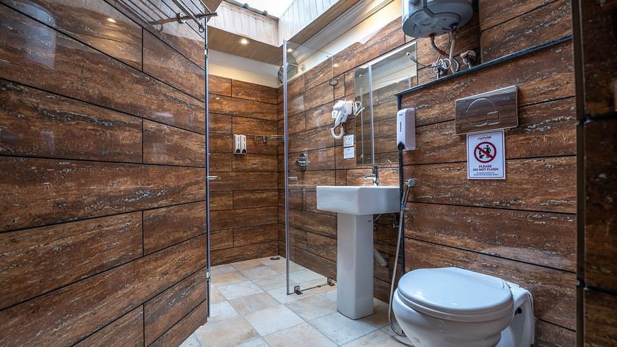  The bathroom of the Premium Suite with a Balcony features a glass partition for the shower area and includes a geyser