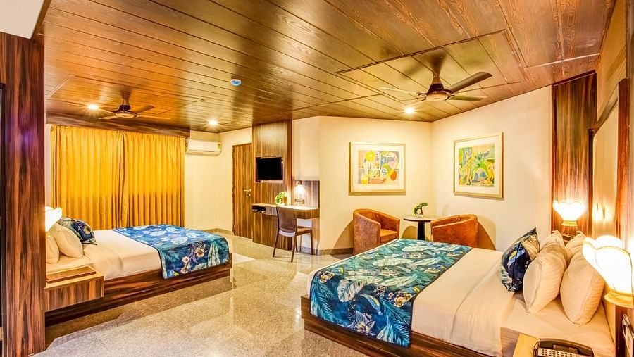  Family room with a private balcony featuring two beds, ceiling fans, and large framed photographs