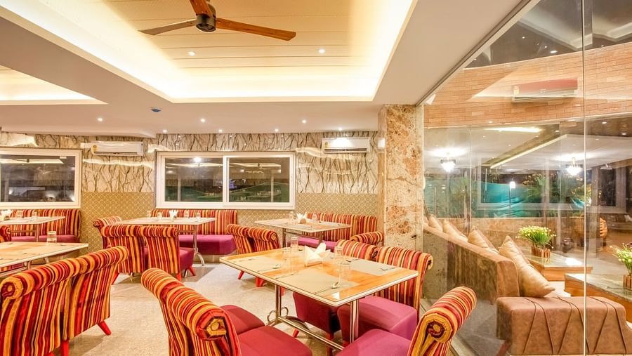  Dining area with cushioned sofas surrounding the table on all four sides, and ceiling fans installed above for added comfort