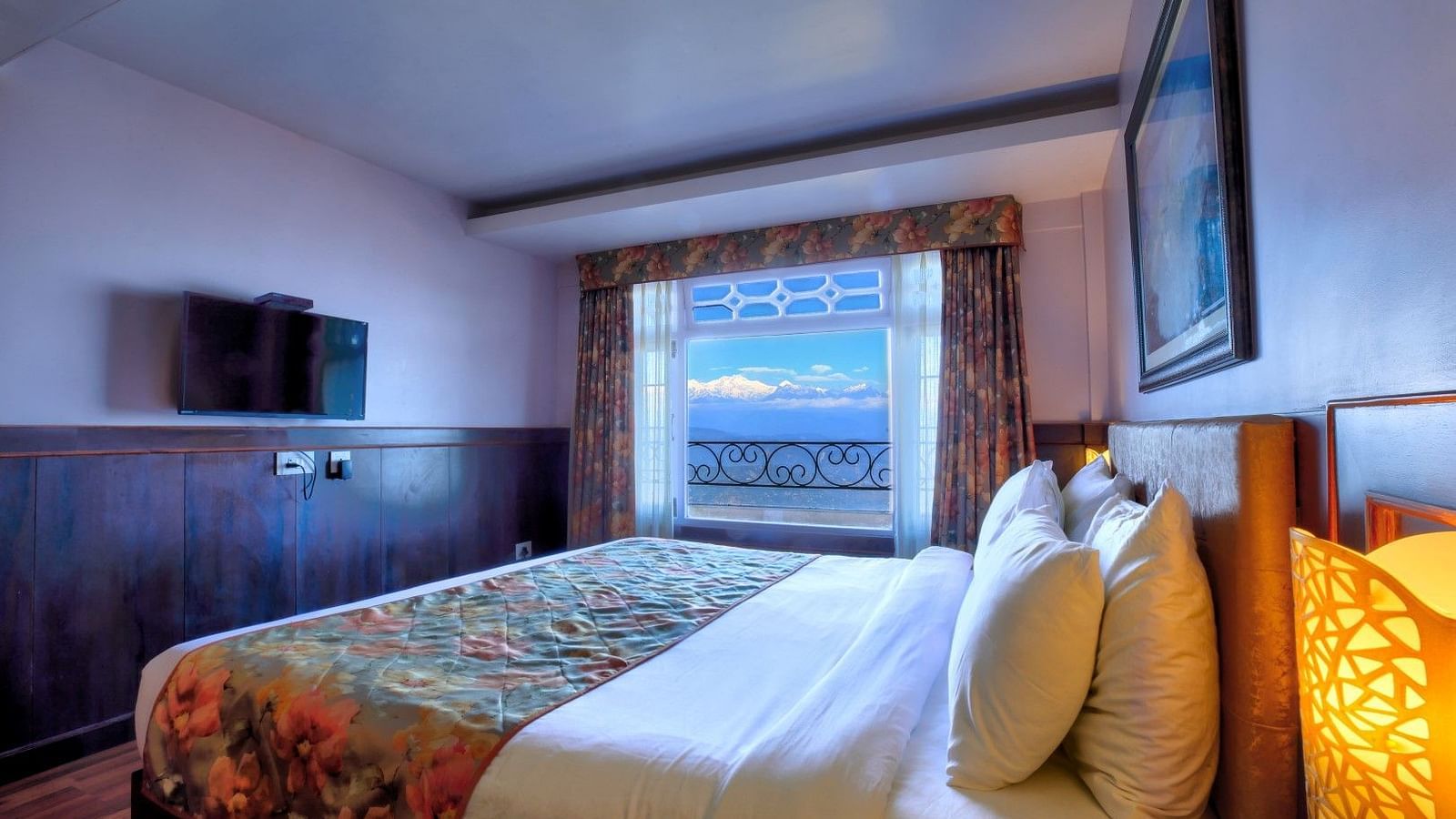 A side view of a bed in a room that has a glass window and TV on the wall | Summit Oakden Resort & Spa, Mall Road