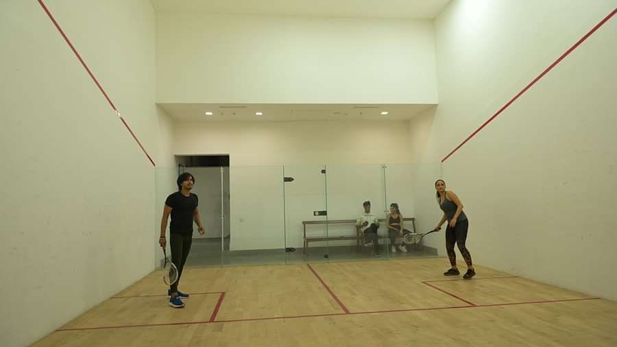 People playing in the squash court at Singalila Club