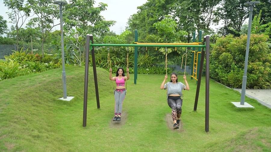 People having fun on swings in a well-manicured garden at Singalila Club