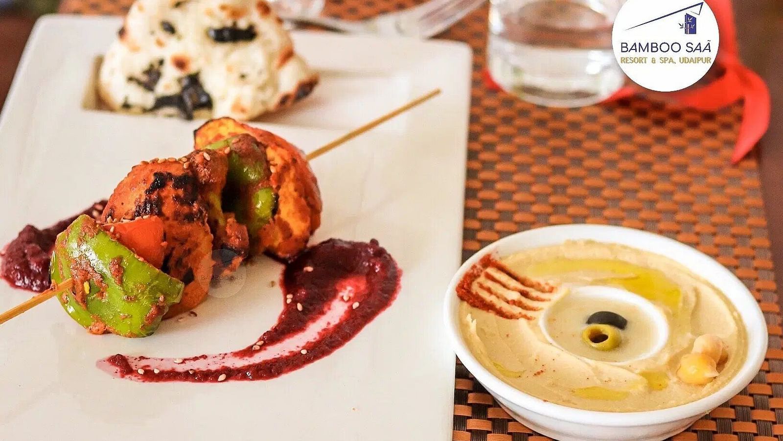 A flat lay of food on a table and a glass of water. - Bamboo Saa, Udaipur