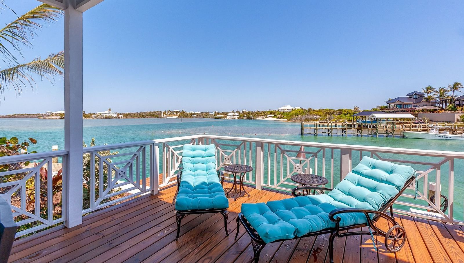 Wooden deck with blue sun loungers overlooking the water | Abaco Inn
