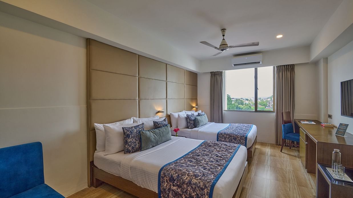 Spacious Premium Family Room at Voyage Milestone Hotel and Banquet with two double beds, bright interiors, and large windows for natural ligh
