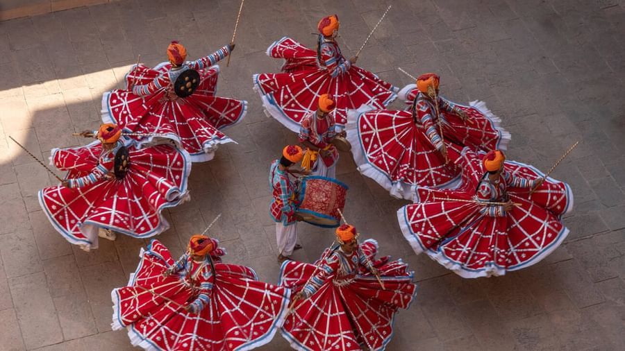 Group of Rajasthani folk dancers performing in vibrant red traditional Ghagra Choli costumes.