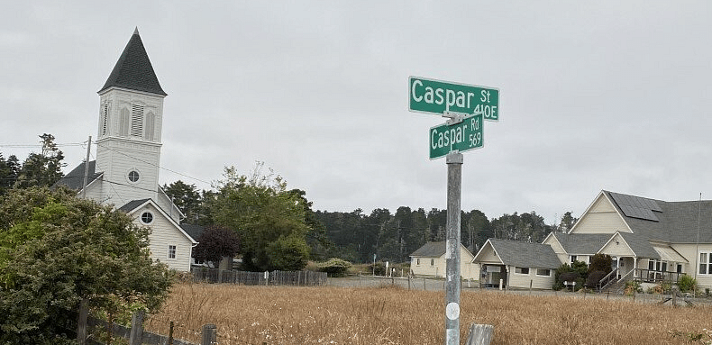 A field with a navigation sign and houses in the vicinity