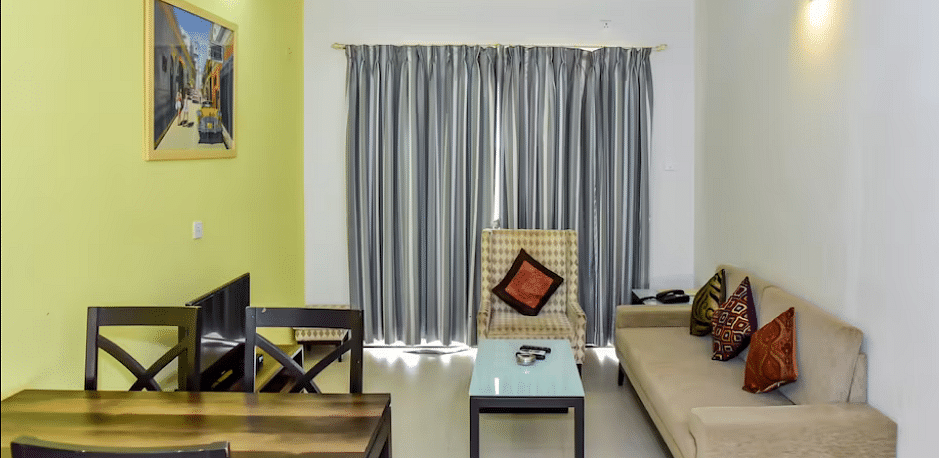 Living and dining space with a sofa and table at La Vida Studio Inn Goa.